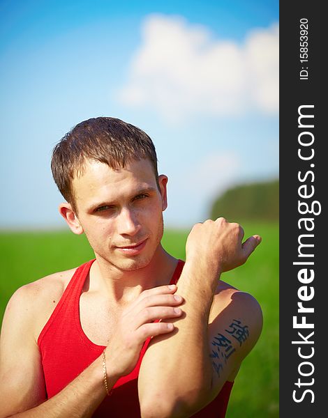 Portrait of a young man in the field against the sky