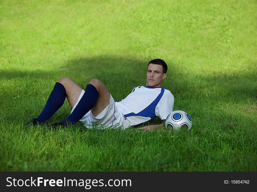 Young soccer player on green grass