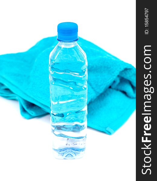 A bottle of water and a sports towel isolated against a white background. A bottle of water and a sports towel isolated against a white background