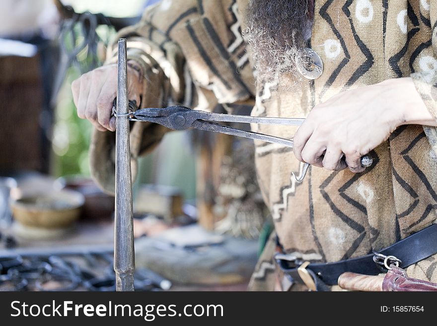 Closeup photo of a blacksmith bending iron with pincers. Closeup photo of a blacksmith bending iron with pincers.