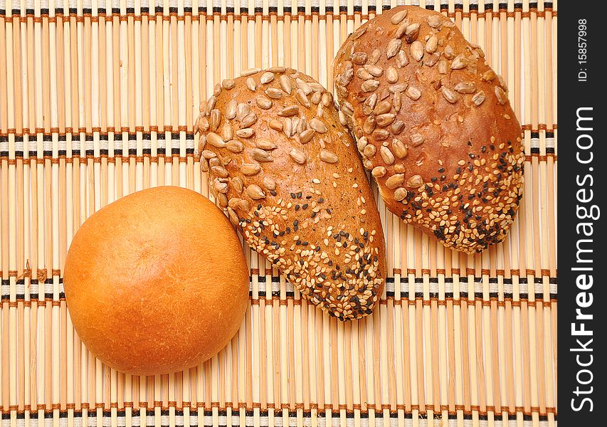 Fresh bread rolls on a straw background