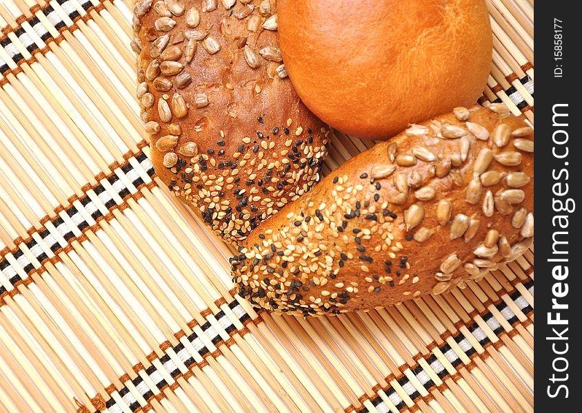 Fresh bread rolls on a straw background