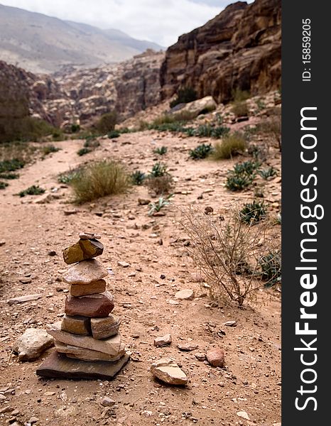 Path with bedouin sign made of stones in Petra, Jordan