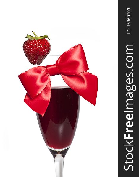 Strawberry and red bow as decoration on the glass of alcohol. Strawberry and red bow as decoration on the glass of alcohol