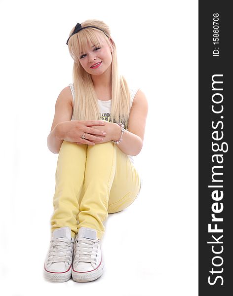 Photograph of pretty young blond girl sitting isolated against white