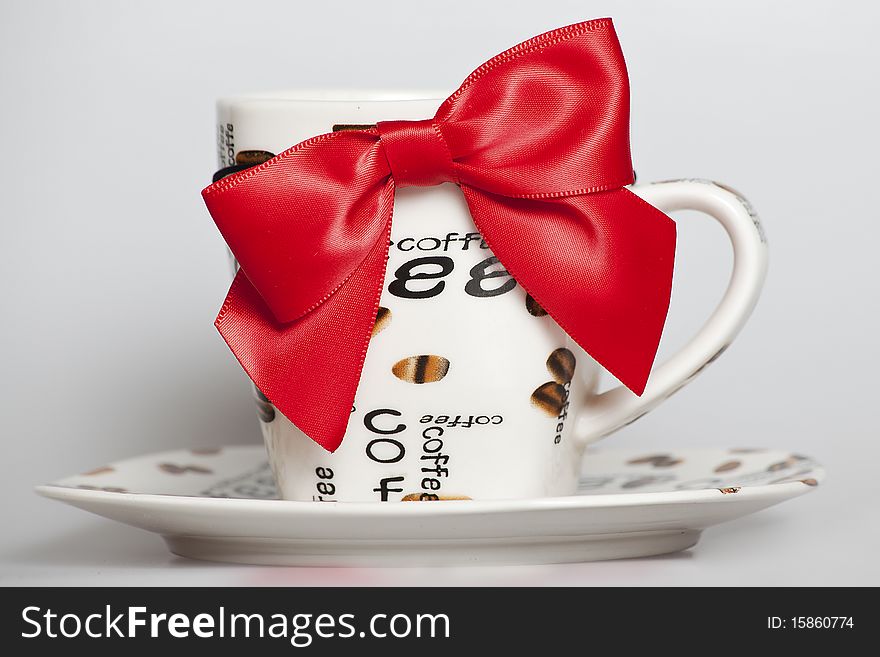 Designed cup of black coffee with red ribbon. Designed cup of black coffee with red ribbon
