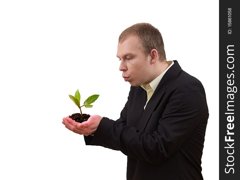 Young businessman keeping small green plant  in his hands, on white background. Young businessman keeping small green plant  in his hands, on white background