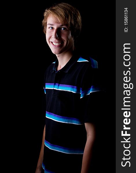 Young teenage boy with a big smile. Isolated over black background. Young teenage boy with a big smile. Isolated over black background.