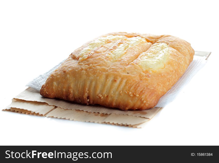A whole pastry with cheese on top isolated on white
