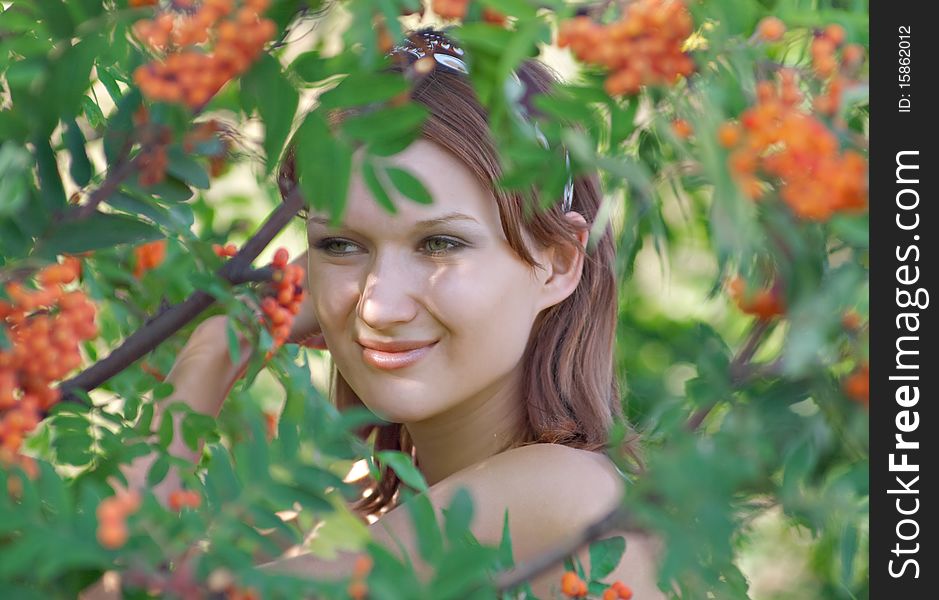 Beautiful girl in the forest with mountain ash