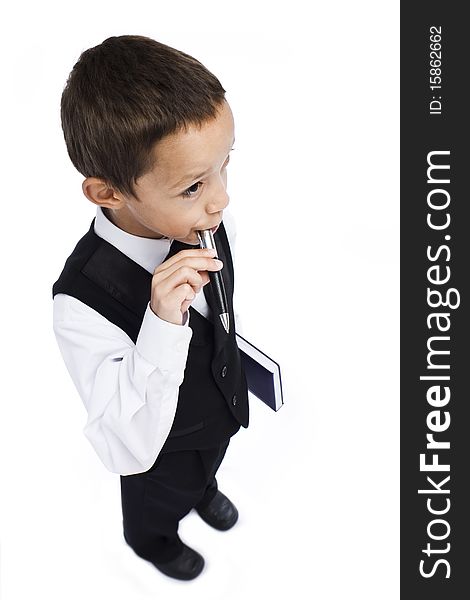 Boy holding pen in his mouth holding book in his hand. Boy holding pen in his mouth holding book in his hand