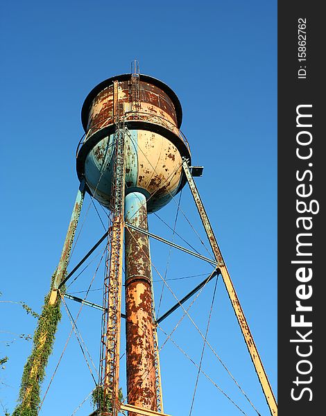 A Old rusty watertower against blue sky. A Old rusty watertower against blue sky