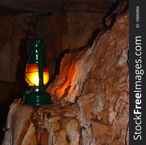 Oil lamp lighting the side of a red wall cave. Oil lamp lighting the side of a red wall cave.