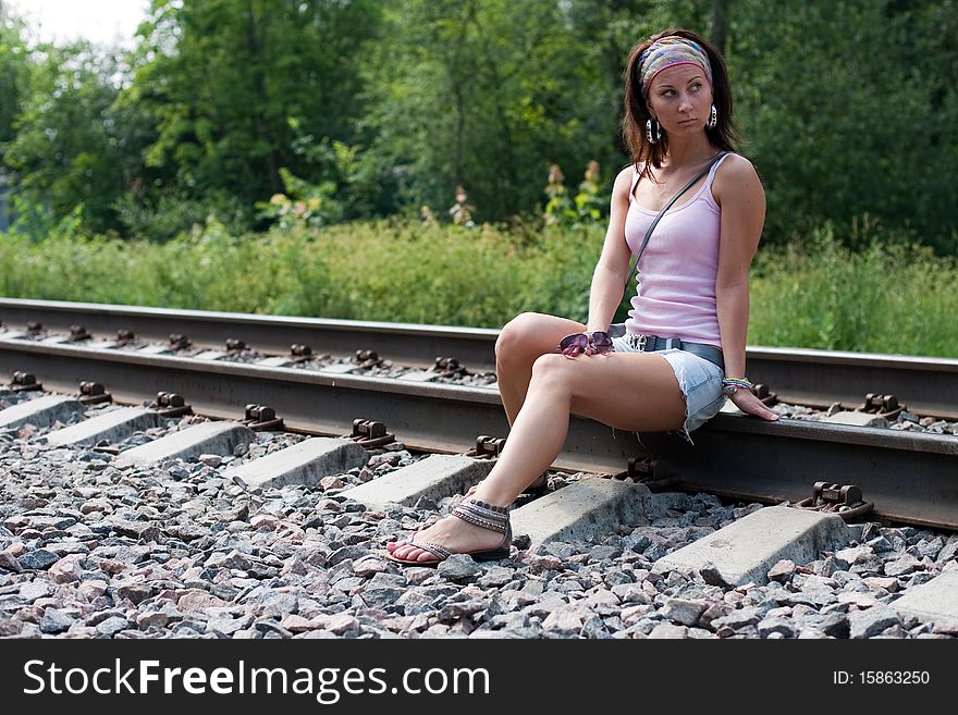 Young beautiful lady is sitting on a railroad. Young beautiful lady is sitting on a railroad
