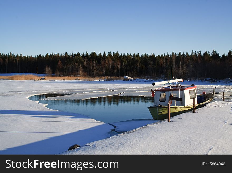 A fishing boat in the boat harbour surrounded by ice. A fishing boat in the boat harbour surrounded by ice
