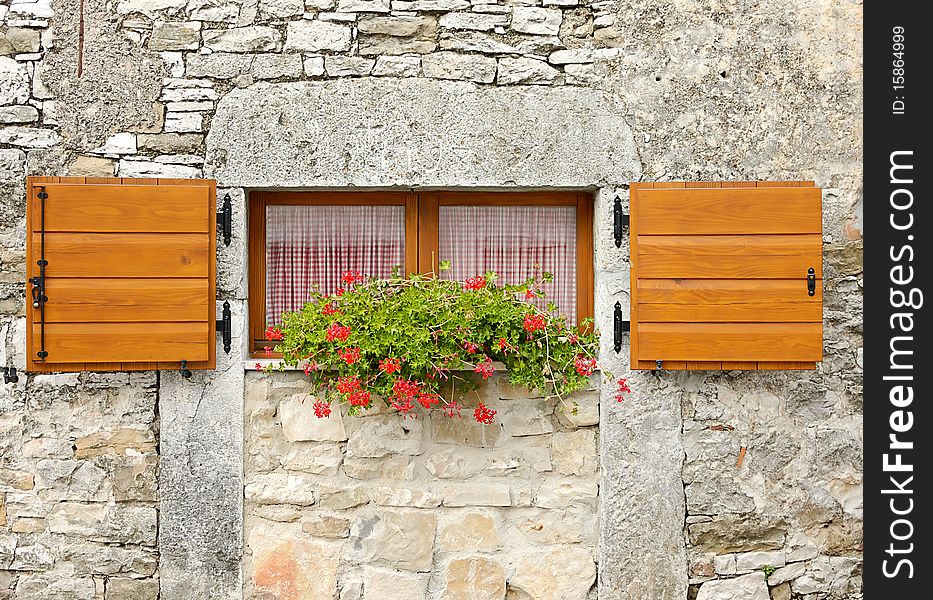 Ancient windows with flowers in the Hum city, the smallest city in the world