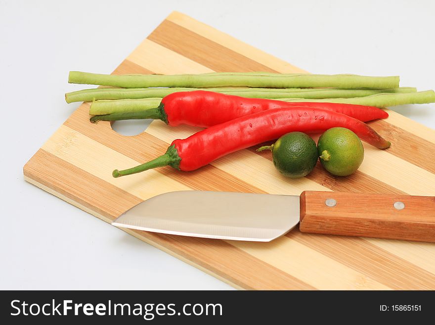 Knife cut board and few vegetables