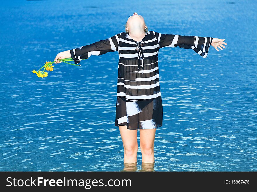 Beautiful woman with flowers in the sea. Beautiful woman with flowers in the sea