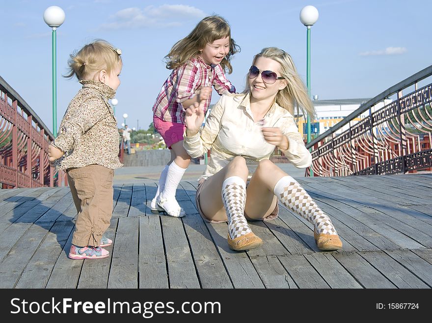 The woman plays with children in the summer fresh air. The woman plays with children in the summer fresh air