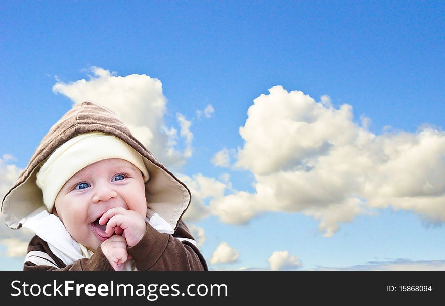 the baby holding hands and laughing on sky background. the baby holding hands and laughing on sky background