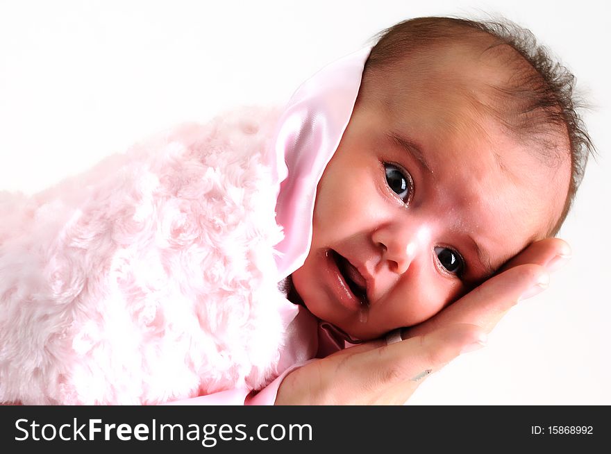 Baby girl wrapped in pink blanket held by father