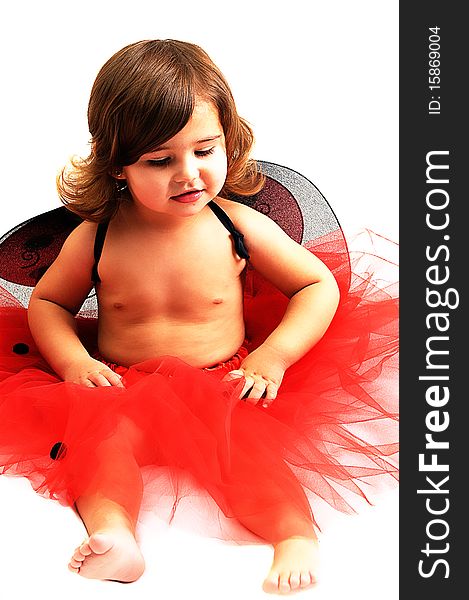 Little girl playing and smiling in studio wearing red angle wings. Little girl playing and smiling in studio wearing red angle wings