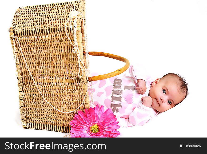 Newborn baby girl in a basket, beads and flower