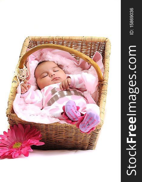 Newborn baby girl laying in a brown basket, white beads and big pink flower. Newborn baby girl laying in a brown basket, white beads and big pink flower