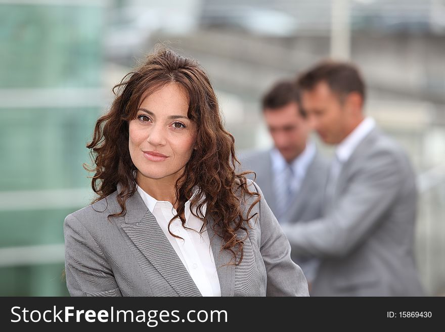 Portrait of businesswoman standing in front of businessemen. Portrait of businesswoman standing in front of businessemen