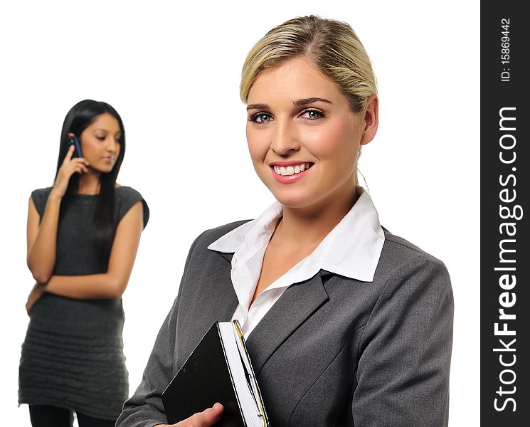 Confident young business woman with co-worker in background. Confident young business woman with co-worker in background