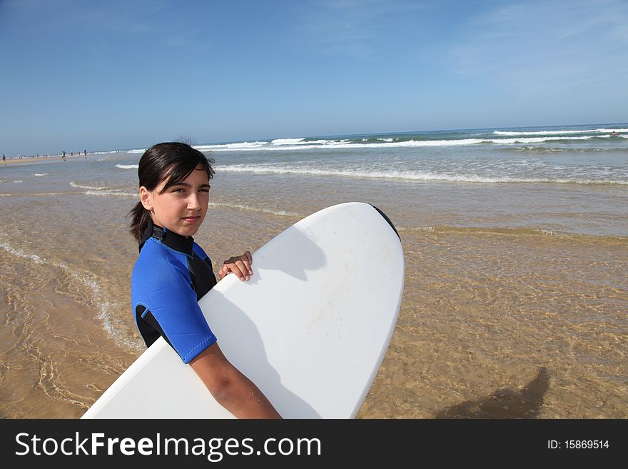 Young girl with surfboard by the beach. Young girl with surfboard by the beach