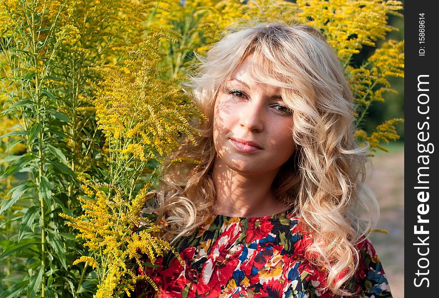 Beautiful young blond woman with wild yellow flowers. Beautiful young blond woman with wild yellow flowers