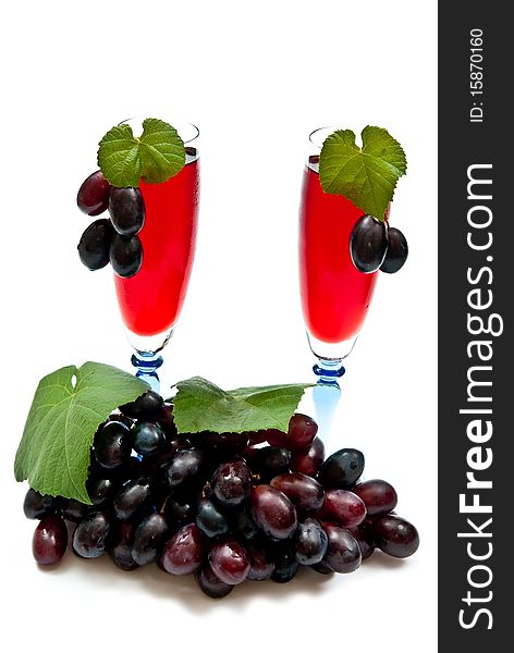 Red grapes with two glasses of red wine. Isolated on white
