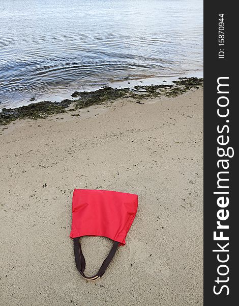 Red bag and seaweeds on the beach. Red bag and seaweeds on the beach.