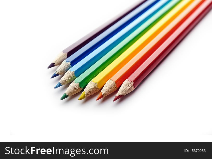 Colored pencils arranged in rainbow spectrum order isolated on white background