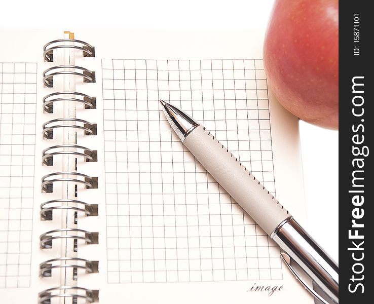 Open notebook, red apple and pen on white. Open notebook, red apple and pen on white