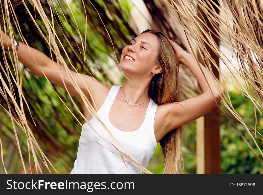 Beautiful young woman outdoors in the summer day.