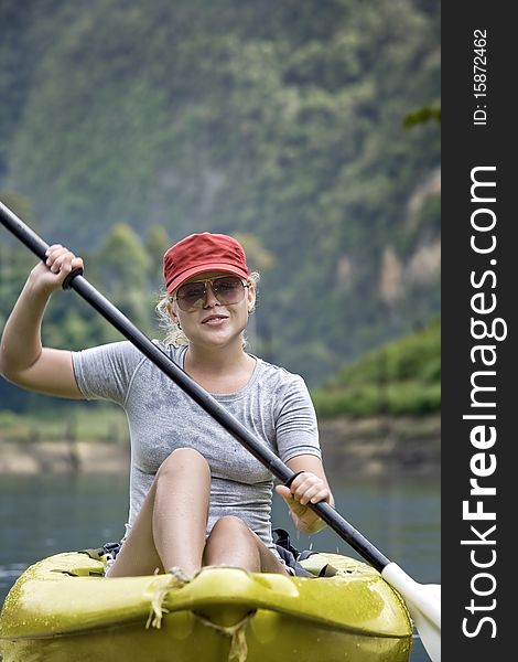 Portrait of nice young woman paddling kayak in summer  environment. Portrait of nice young woman paddling kayak in summer  environment