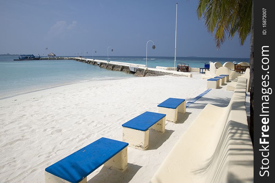 Maldives. A view with ocean, coast and a raw of benches. Maldives. A view with ocean, coast and a raw of benches