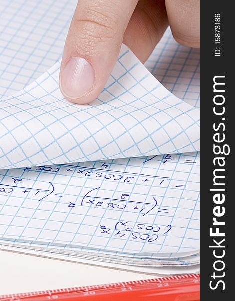Student folding a page in a math notebook.