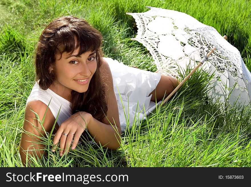 Young  beautiful girl  with sun umbrella relaxing in the fresh green grass. Young  beautiful girl  with sun umbrella relaxing in the fresh green grass
