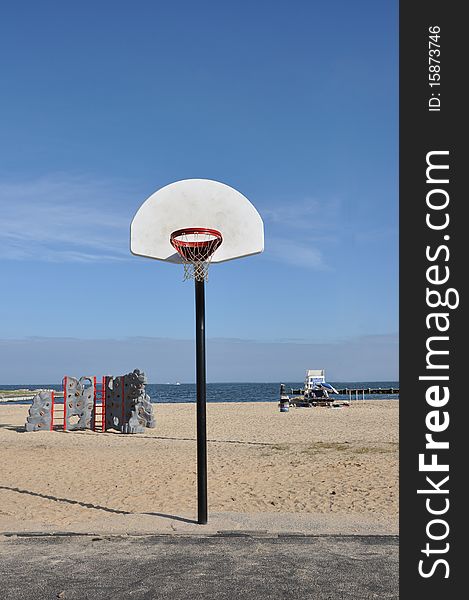 Baskeball hoop rock climbing activity center and lifeguard station on beach under clear blue sky. Baskeball hoop rock climbing activity center and lifeguard station on beach under clear blue sky