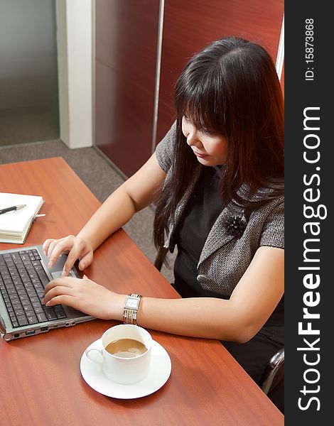 Asian business woman at work in front of notebook. Asian business woman at work in front of notebook