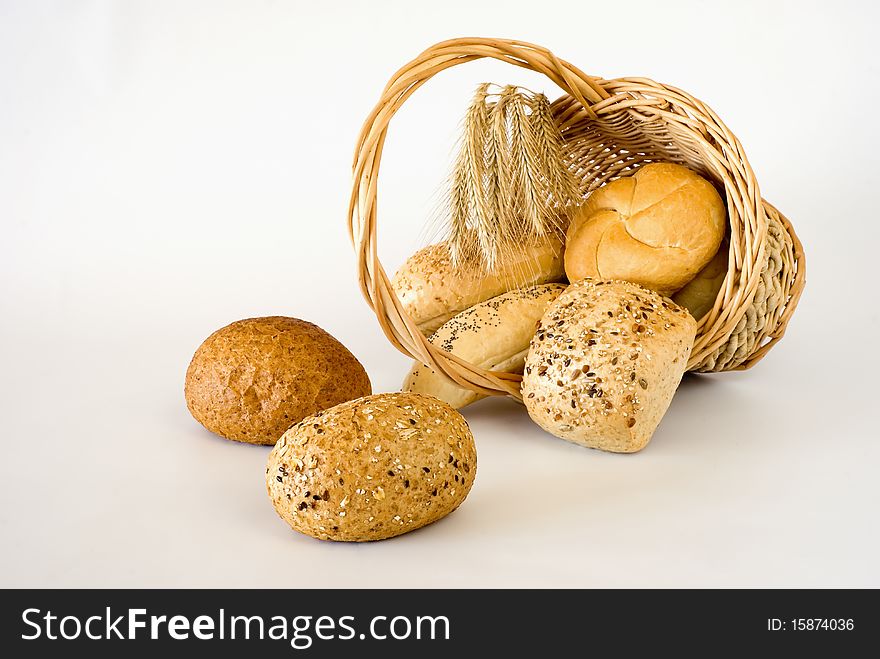 Basket turned over with the fresh bread on the white background. Basket turned over with the fresh bread on the white background