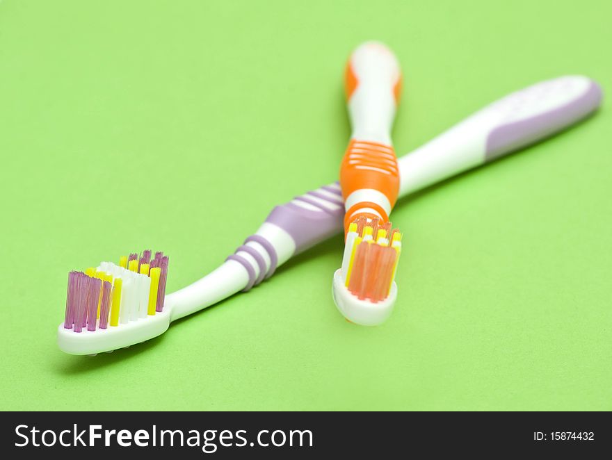 Colourful toothbrushes on the green background