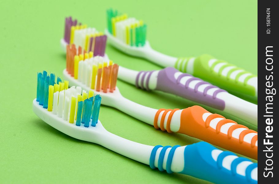 Colourful toothbrushes on the green background