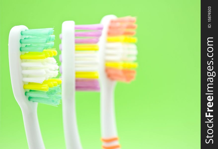 Colourful toothbrushes on the green background