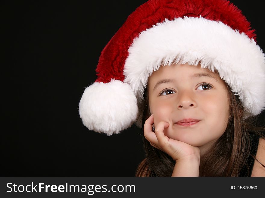 Cute little brunette girl wearing a christmas hat. Cute little brunette girl wearing a christmas hat