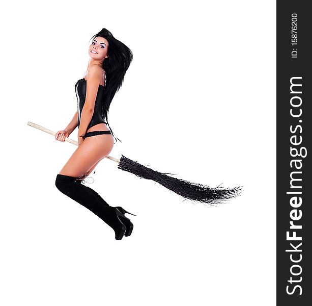 Pretty young brunette witch flying on a broom. Pretty young brunette witch flying on a broom