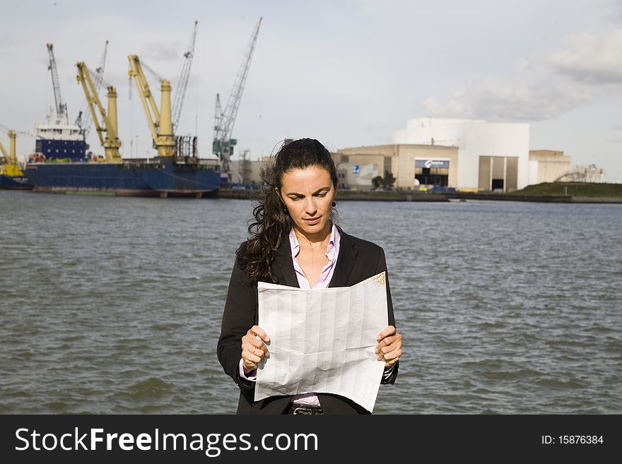 Young businesswoman watching at a map in port of Rotterdam. Young businesswoman watching at a map in port of Rotterdam